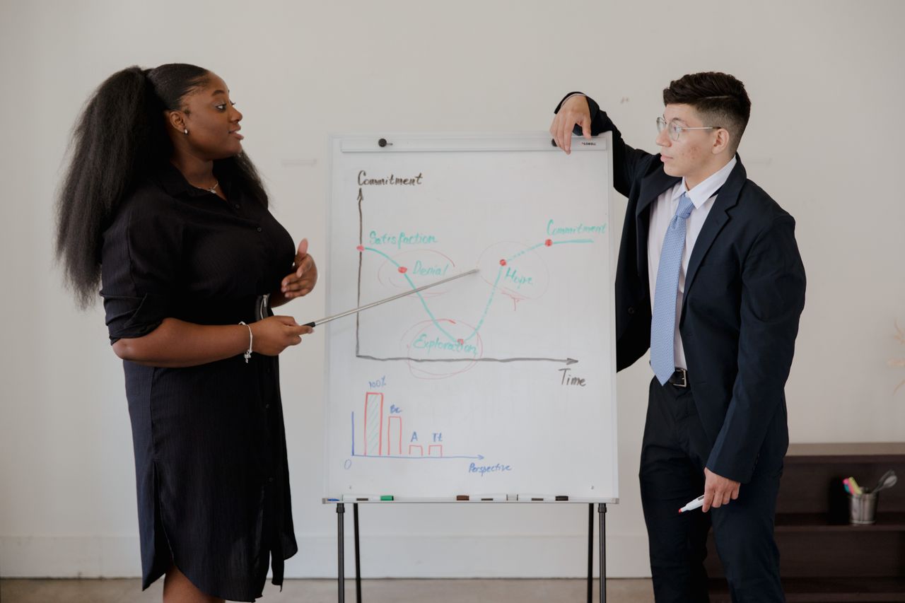 Two professionals discussing a business graph during a meeting.